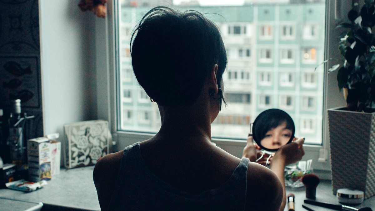 Девушка смотрит в зеркало