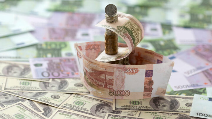 Доллары и евро лежат на столе, из рублей сделан корабль