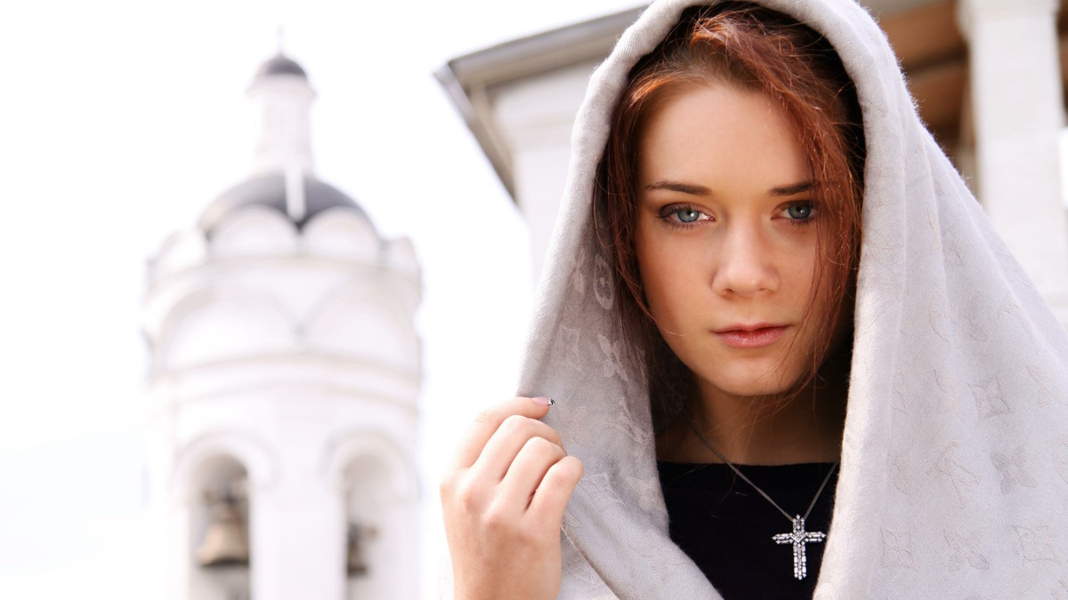 Девушка в платке на фоне церкви
