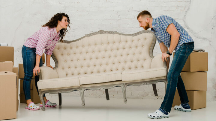 Мужчина и женщина двигают диван