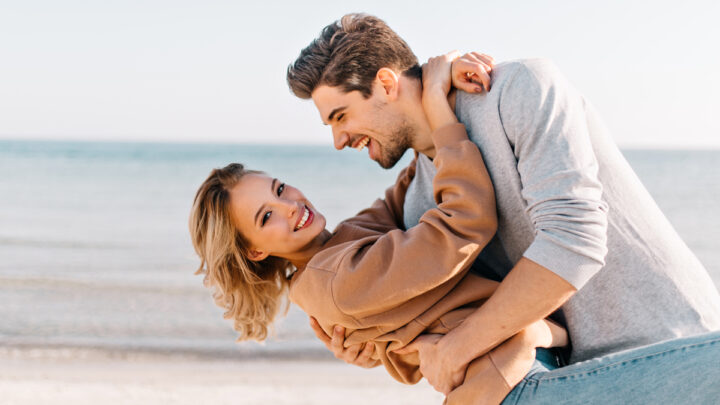 Блондинка с короткой стрижкой обнимает мужа на пляже
