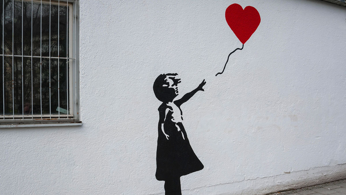 Рисунок девочки на стене от которой улетает красный шарик в видео сердца
