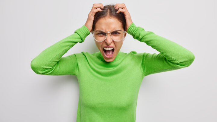 Женщина проявляет негативные эмоции в очках, кричит