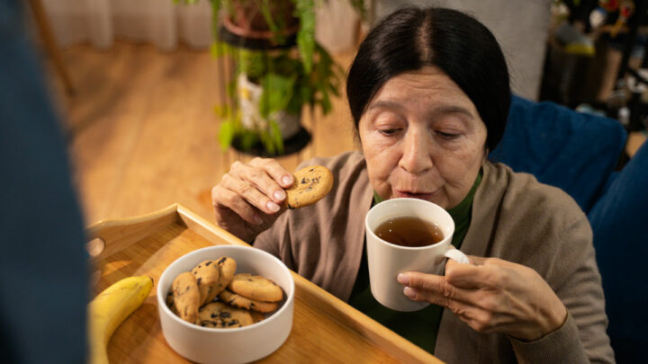 Женщина пьет чай с печеньями