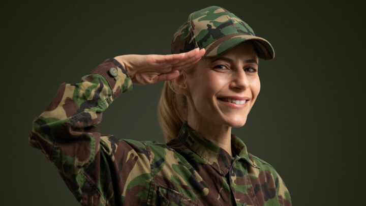 Женщина военный отдает честь, улыбается