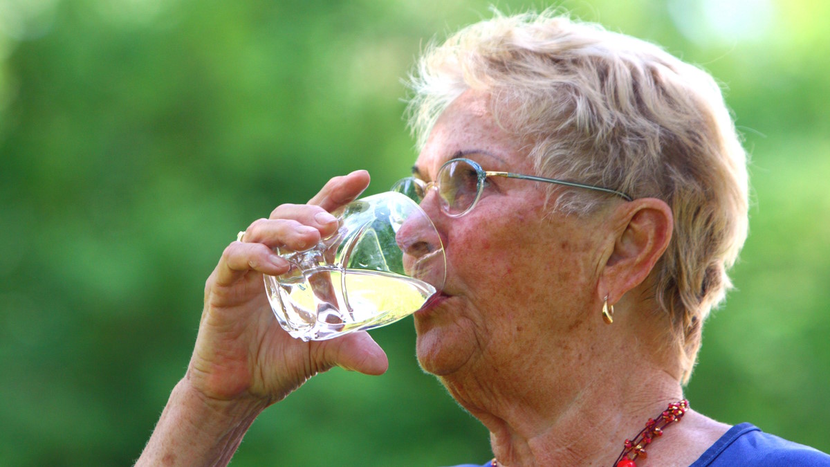 Женщина пьет из стакана