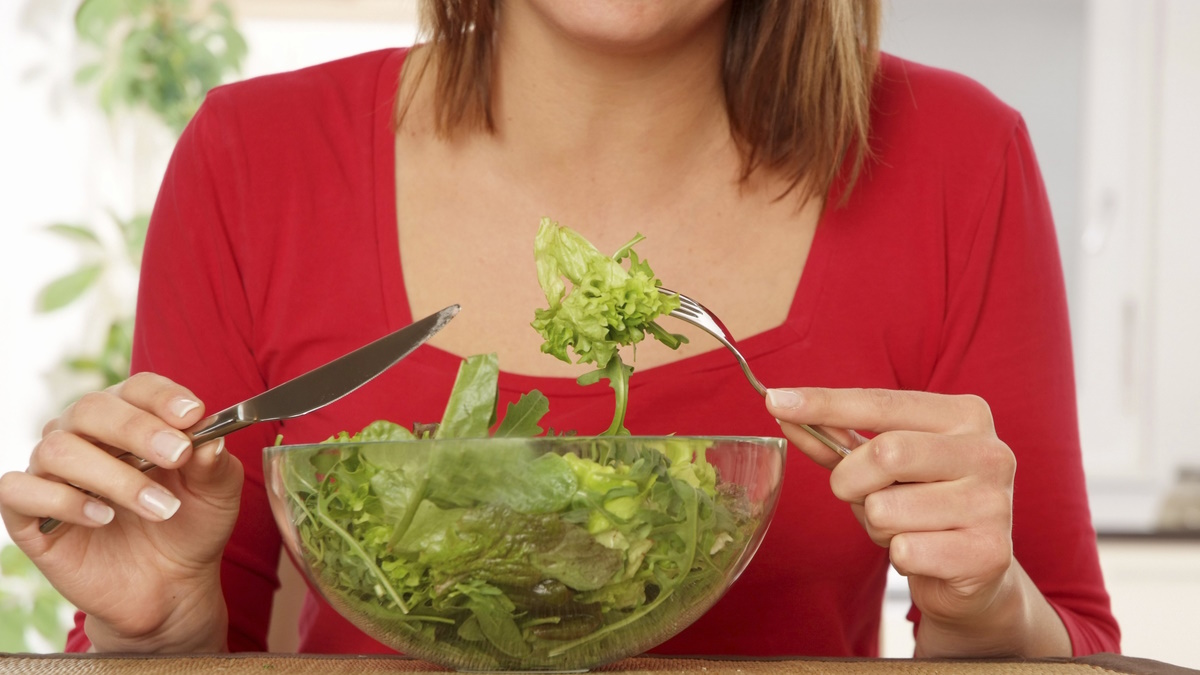 Женщина ест салат
