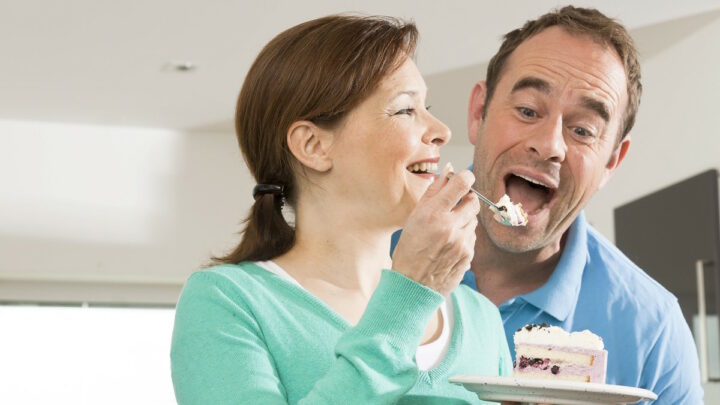 Женщина кормит мужчину тортом