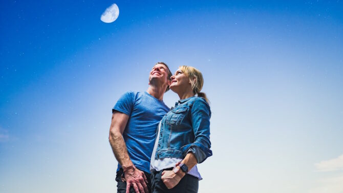 Мужчина и женщина смотрят в небо на луну