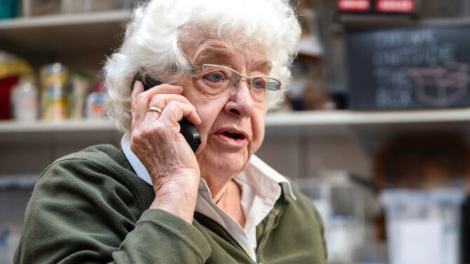 Пожилая женщина разговаривает по мобильному телефону