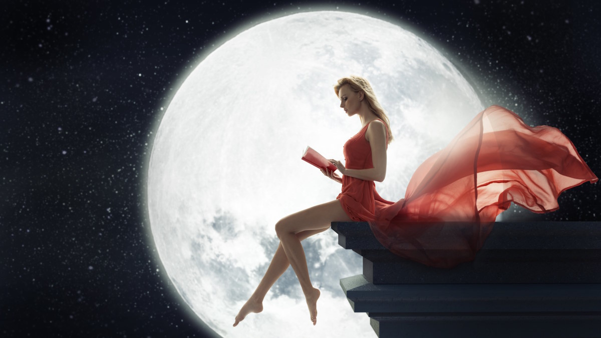 Девушка держит в руках книгу на фоне луны