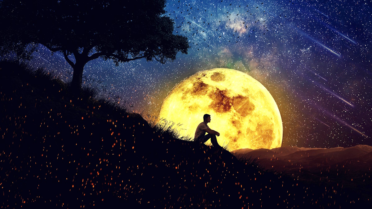 Мужчина сидит на холме на фоне большой луны