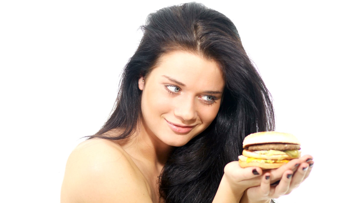 Девушка жадно смотрит на бургер