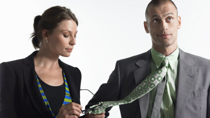 Женщина протирает свои очки галстуком мужчины
