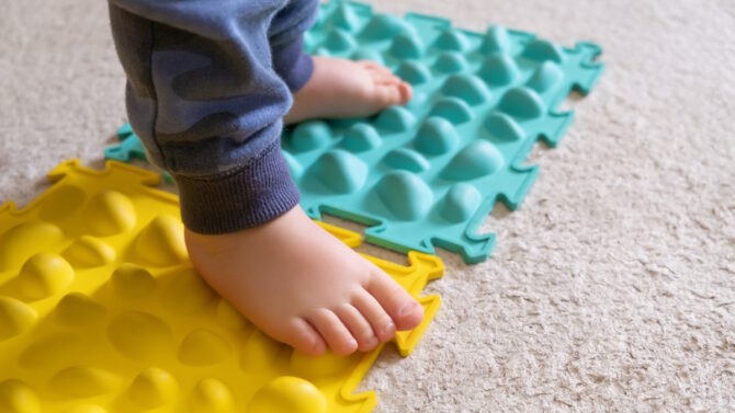Детские ноги на массажном коврике