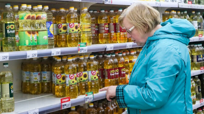 Женщина в супермаркете у полки с растительным маслом