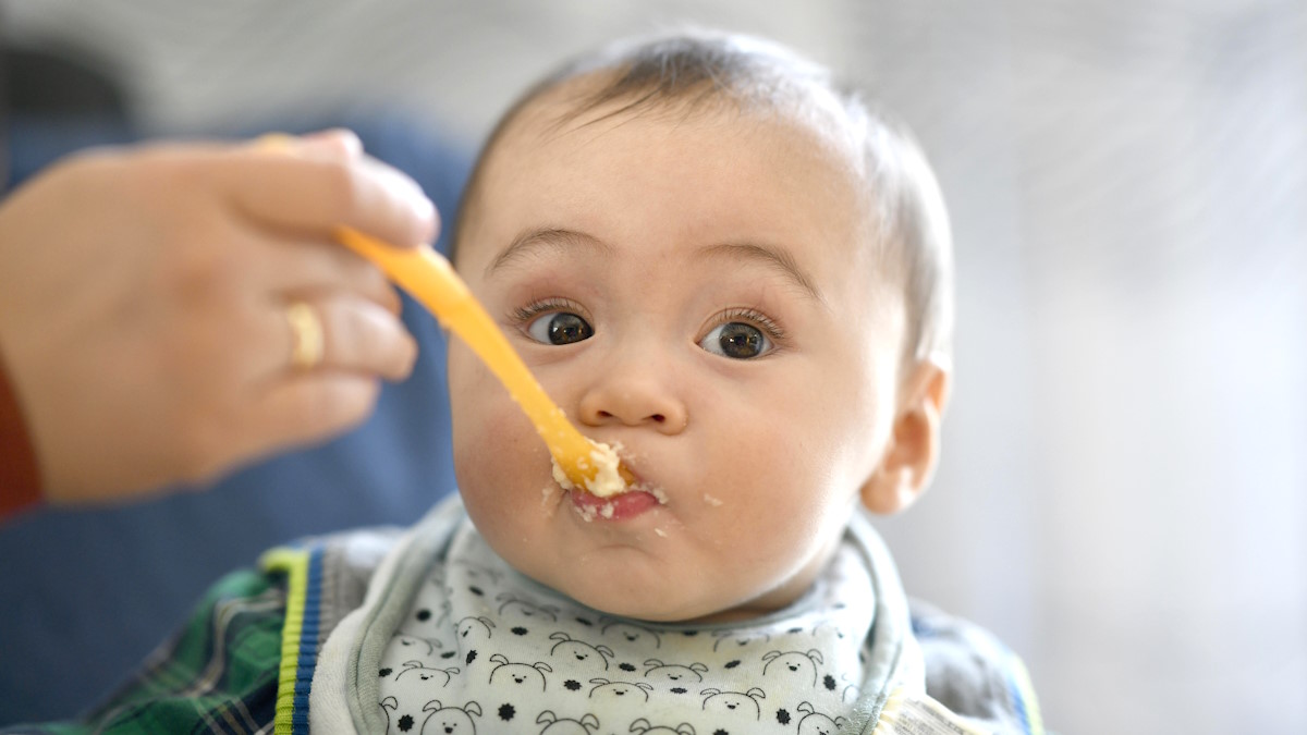 Ребенка кормят кашей
