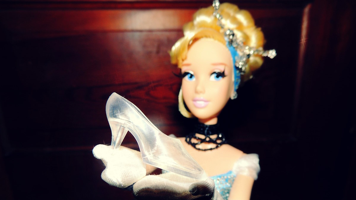 Кукла держит в руках хрустальную туфельку