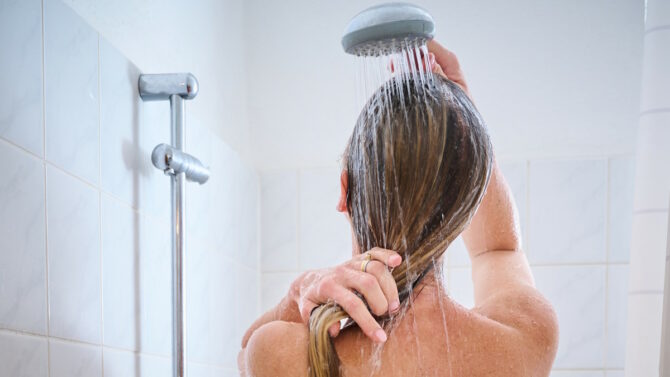 Женщина моет голову под душем