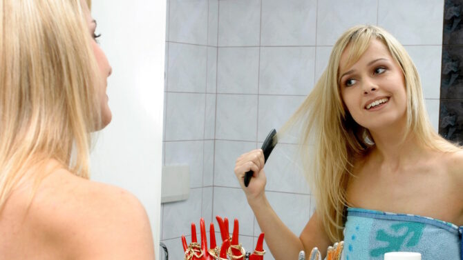 Женщина расчесывает волосы