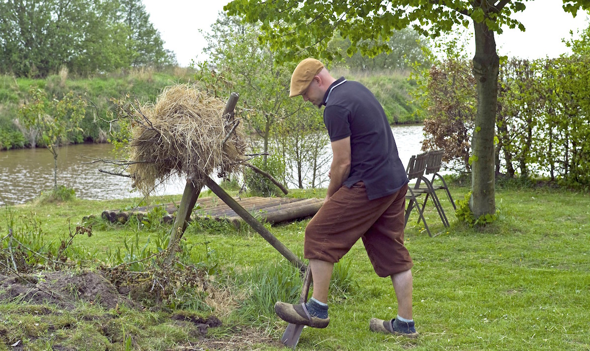 Мужчина с лопатой работает в саду