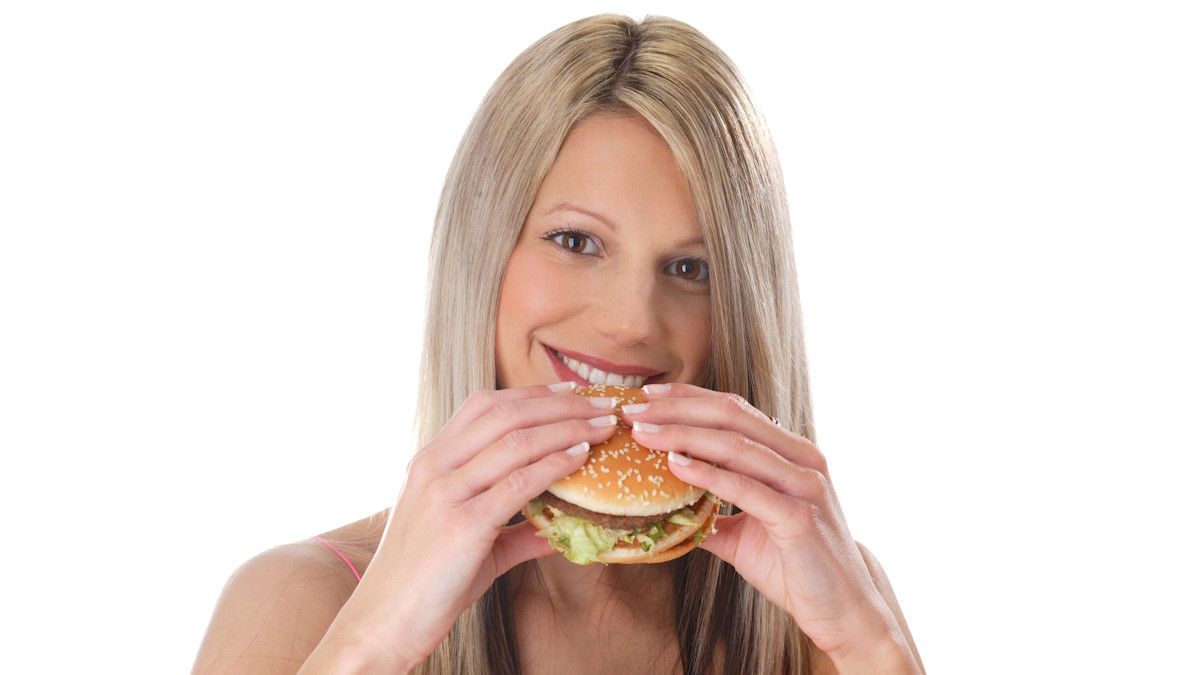 Женщина ест бургер
